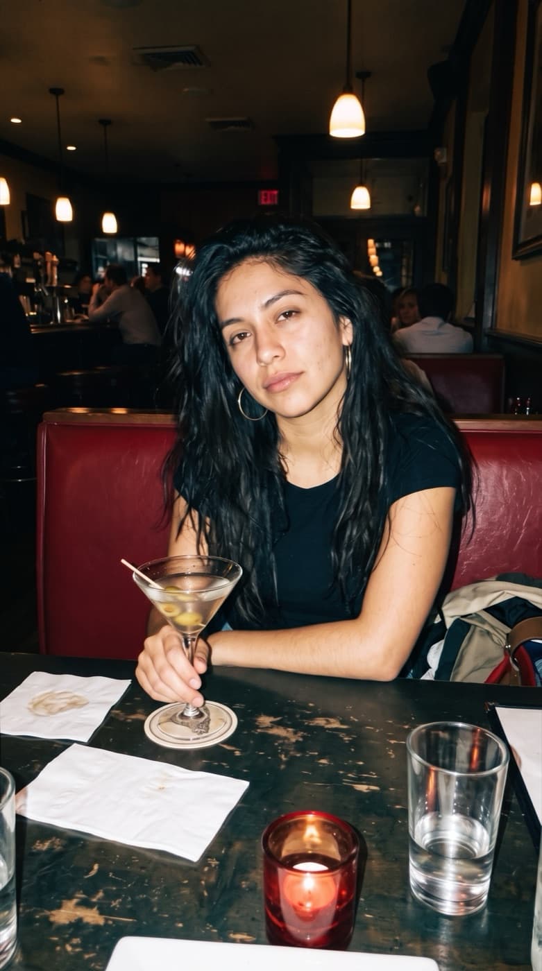 A woman at a restaurant table holding a martini, with the Digicam Flash look